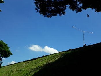 Low angle view of windmill on field against sky