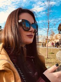 Young woman wearing sunglasses against sky