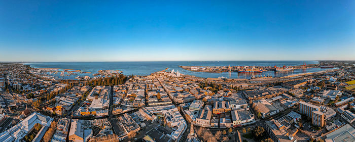 High angle view of sea and buildings against clear sky