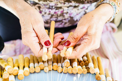 Midsection of woman holding threads