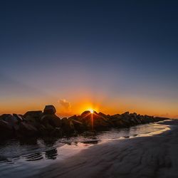 Scenic view of sea against clear sky during sunset