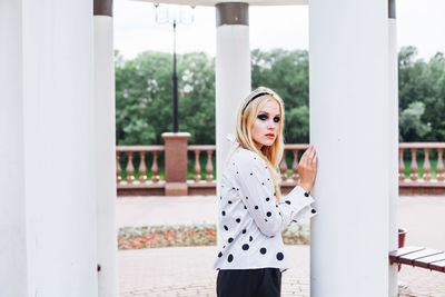 Portrait of young woman standing in gazebo