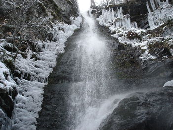Low angle view of waterfall against sky