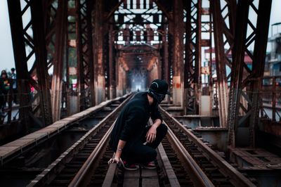 Side view of man standing on railroad track