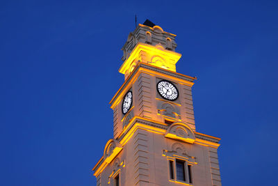 Low angle view of clock tower against clear blue sky