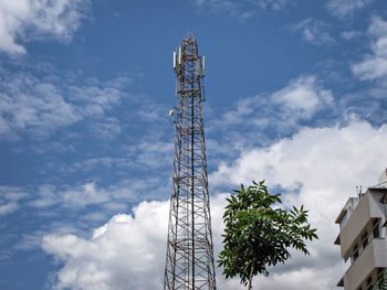 Low angle view of ferris wheel against cloudy sky