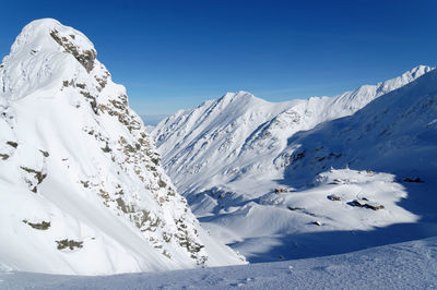 Scenic view of snowcapped mountain against blue sky