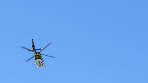 Low angle view of airplane against clear blue sky