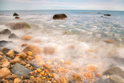 Scenic view of rocks in sea against sky