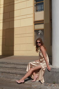 Young female model posing against building
