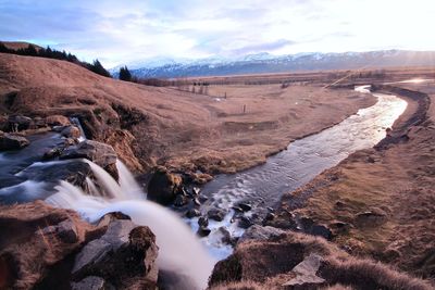 Scenic view of waterfall against sky