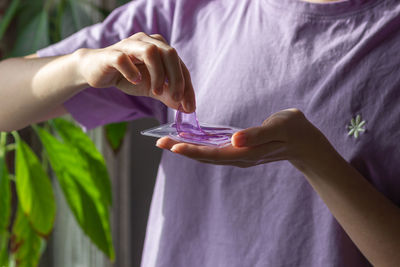Woman hands hold purple hydrogel eye patches, ready for use cosmetics against wrinkles and puffiness