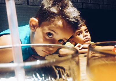 Close-up portrait of boys looking at glasses 