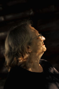 Portrait of elderly woman in glasses close-up on natural background. profile of man with sun