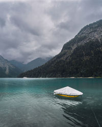 Scenic view of lake by mountains against sky