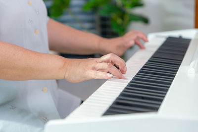 Midsection of woman playing piano