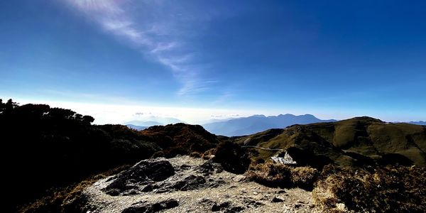 Scenic view of mountains against blue sky