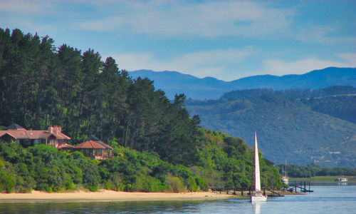 Scenic view of sea and mountains against sky