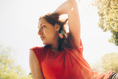 Low angle view of young woman against sky