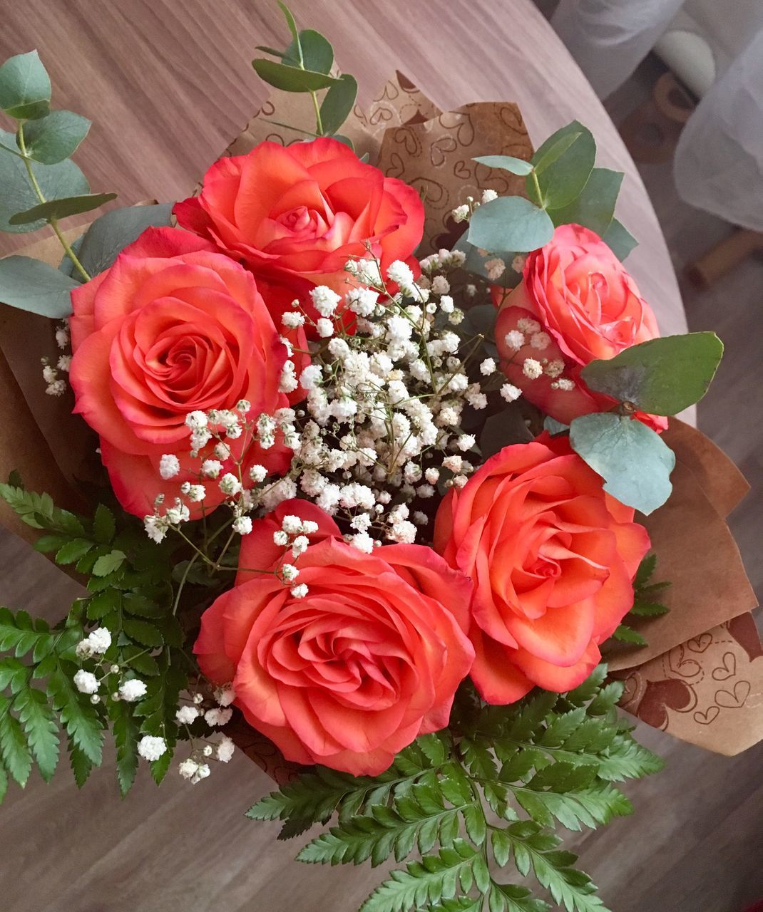 HIGH ANGLE VIEW OF ROSE BOUQUET ON RED TABLE