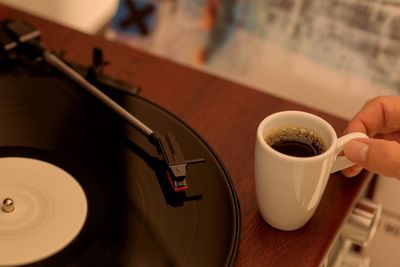 High angle view of hand holding coffee cup on turntable