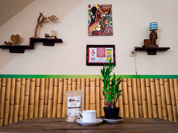 Potted plant on table against wall