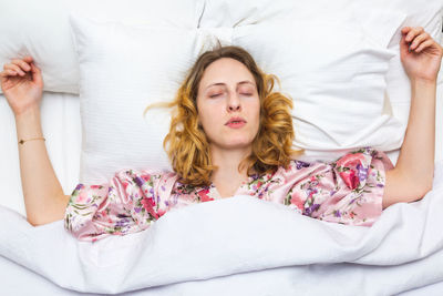 Young woman lying down on bed