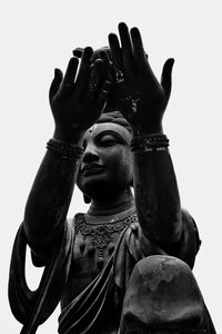 Low angle view of statue against temple against clear sky