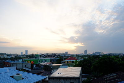 High angle view of cityscape against cloudy sky