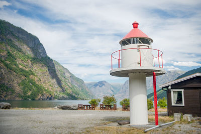 Lighthouse by lake against mountain