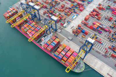 Container ship in export and import business and logistics. shipping cargo to harbor by crane.