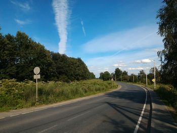 Empty road with trees in background