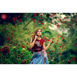 Portrait of woman standing on red plant