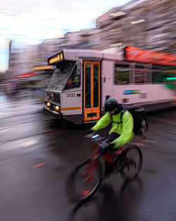 Blurred motion of man riding bicycle on road