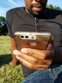 Close-up of man photographing using mobile phone