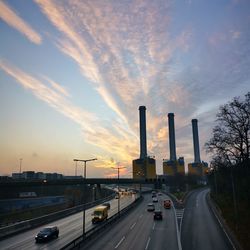 Cars on road against sky during sunset