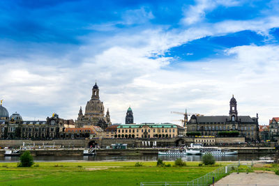 Statue of temple in city against cloudy sky