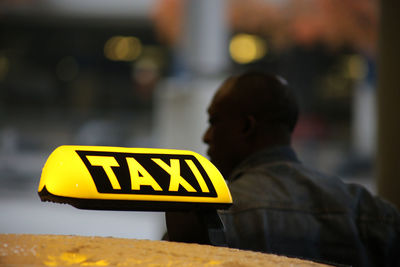 Close-up of yellow sign in city