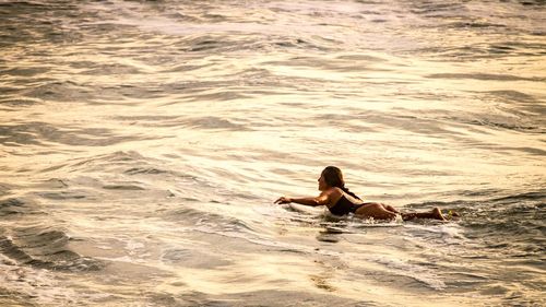 Full length of woman lying in sea