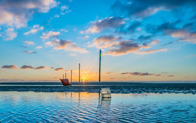 Sailboats in sea against sky during sunset