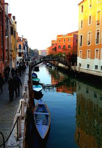 Canal in city against clear sky