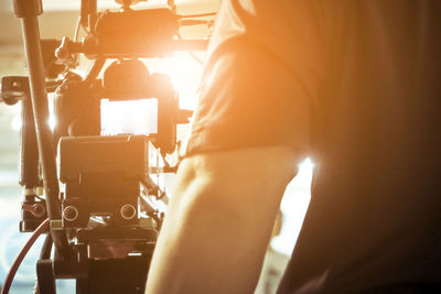 Midsection of man standing in front of television camera