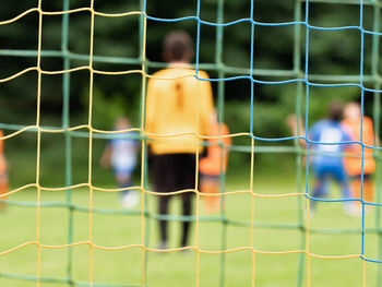 View through soccer gate net. g
oalkeeper slowly backs up during the opponents attack. abstract view