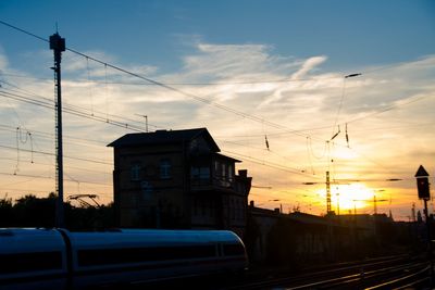 Railroad tracks against sky at sunset