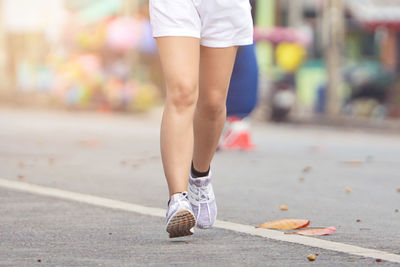 Low section of woman walking on street