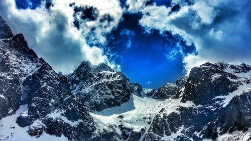 Scenic view of mountain range against cloudy sky