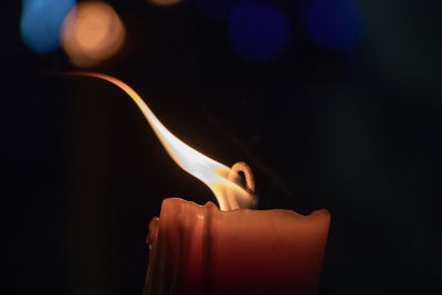 Close-up of lit candle against black background