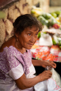 Portrait of old woman selling traditional food on the street market in mexico.