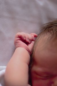 Cropped image of baby girl sleeping on bed