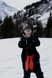 Full length of woman standing on snow covered field